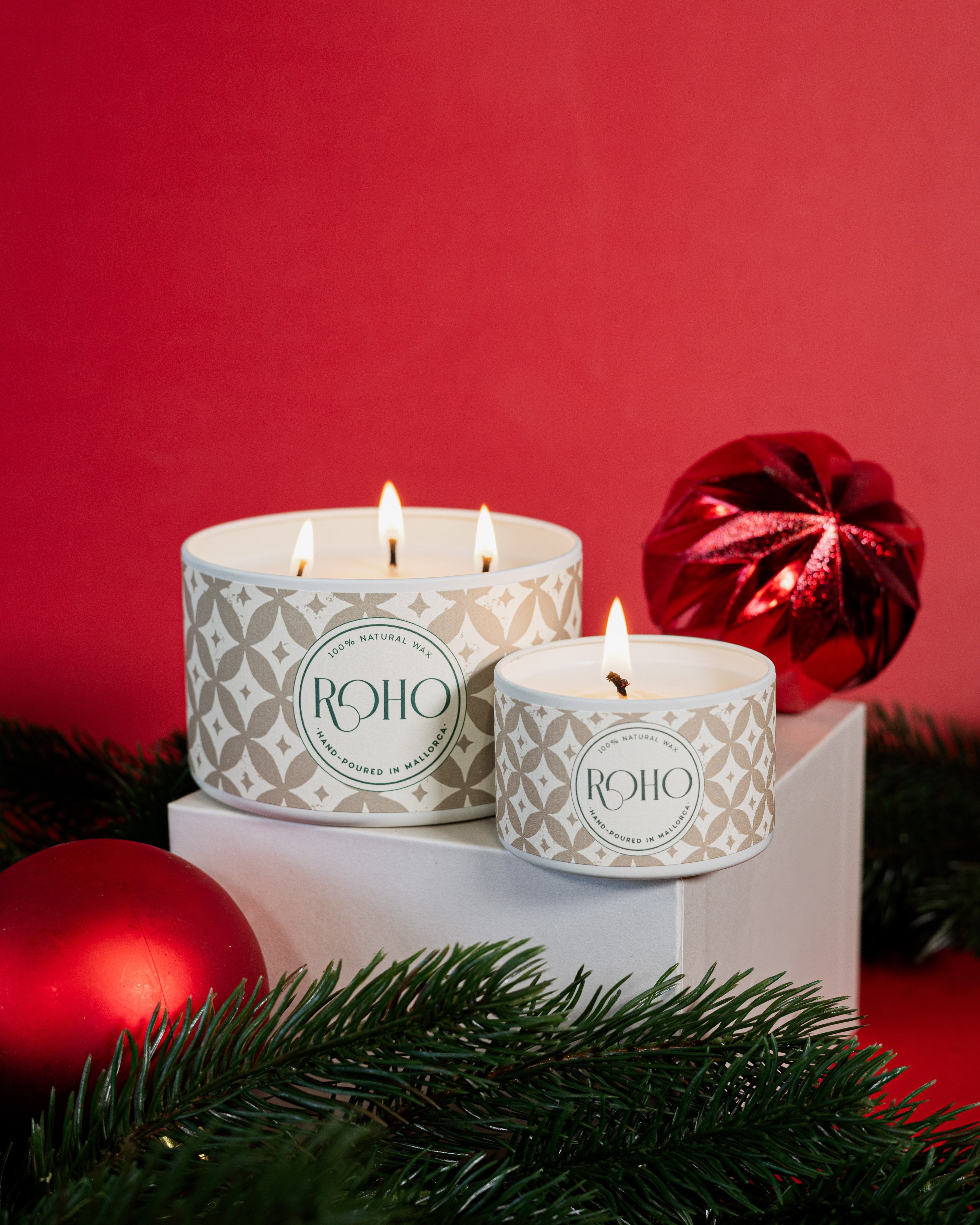 Two lit candles in decorative containers with &