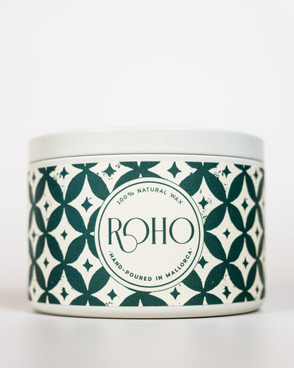 Scented Candle with a decorative patterned label on a green background. Winter Candle, Orange and Cinnamon scent, Winter Candle