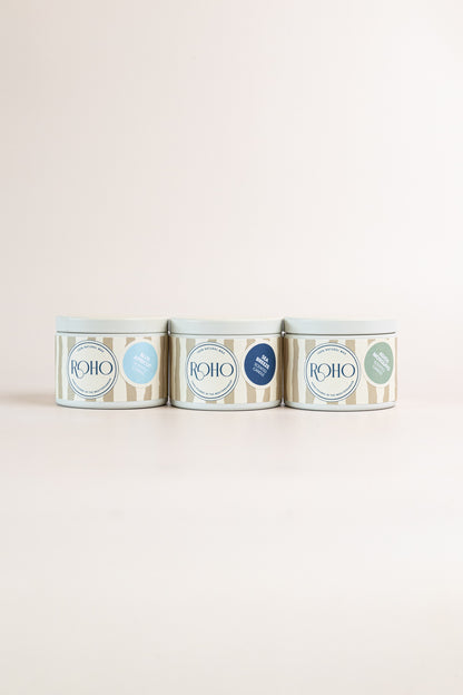 Three ROHO 90g candles in beige tins side by side – Blue Apricot, Sea Breeze and Adiós Mosquito